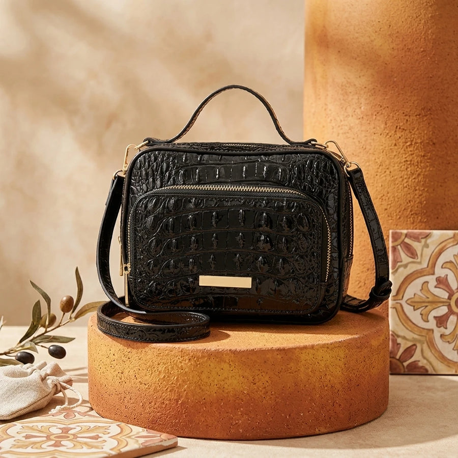 Crocodile-embossed satchel side and hardware detail