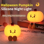 Pumpkin silicone night light glowing on a bedside table
