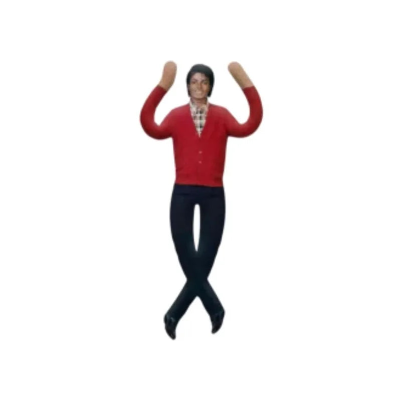 A small figurine of a person with dark hair wearing a red cardigan, a plaid shirt, and dark pants, posed with arms raised and legs crossed, on a plain white background.