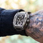 Silver-tone tonneau chronograph watch worn on a tattooed wrist