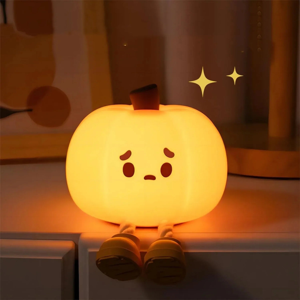 Warm pumpkin night light glowing beside a bed